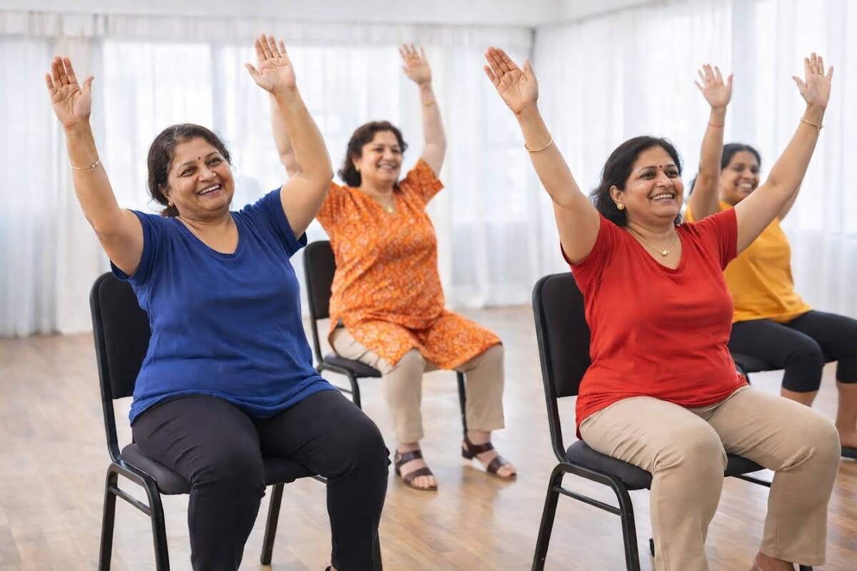 Women taking part in a joyful seated dance session, arms raised